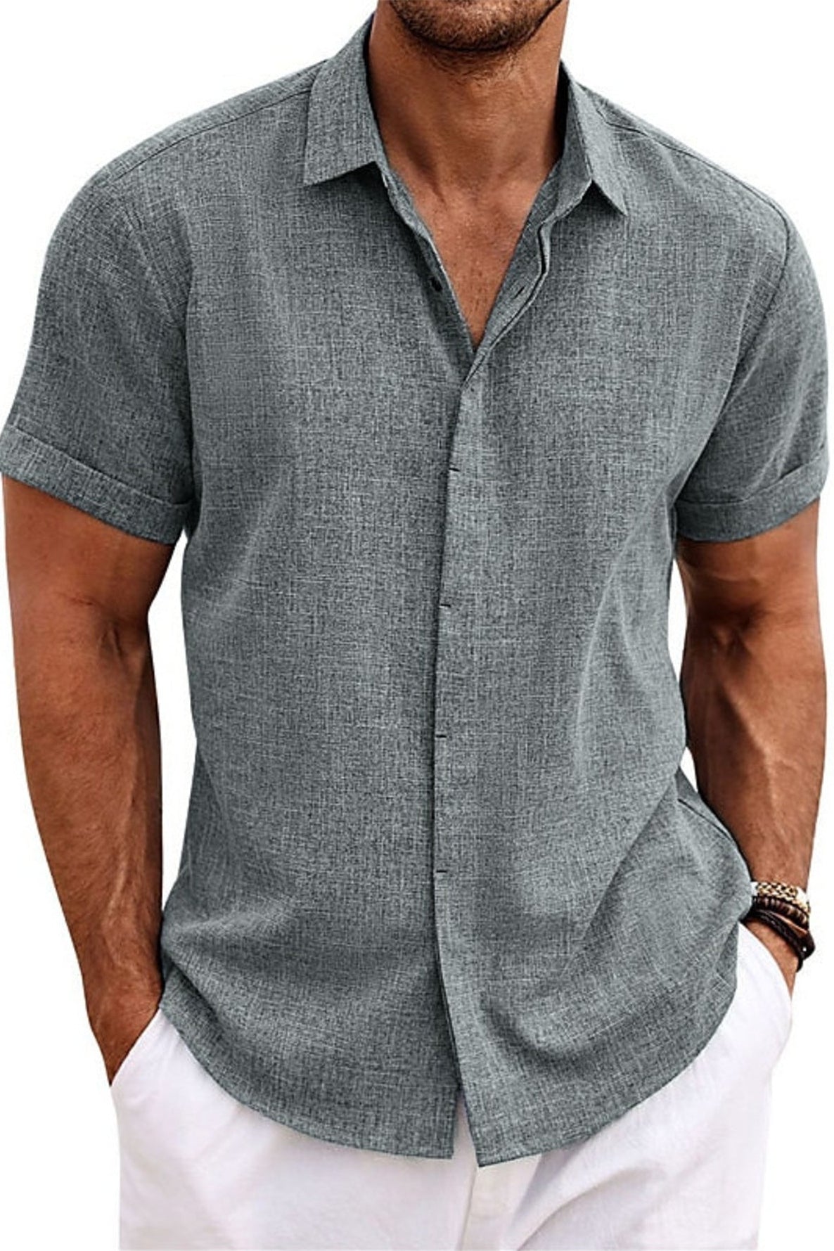 Man wearing a gray short-sleeve button-up shirt with white pants on a white background