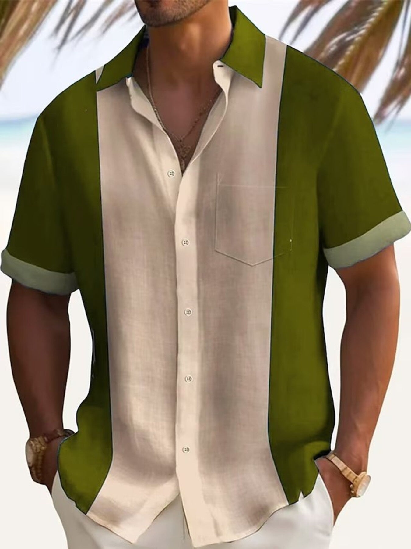 Man wearing a green and beige short-sleeve shirt with a blurred beach background