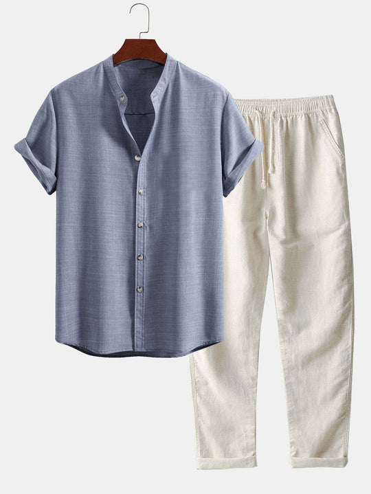 Blue linen shirt and white pants on a hanger against a white background