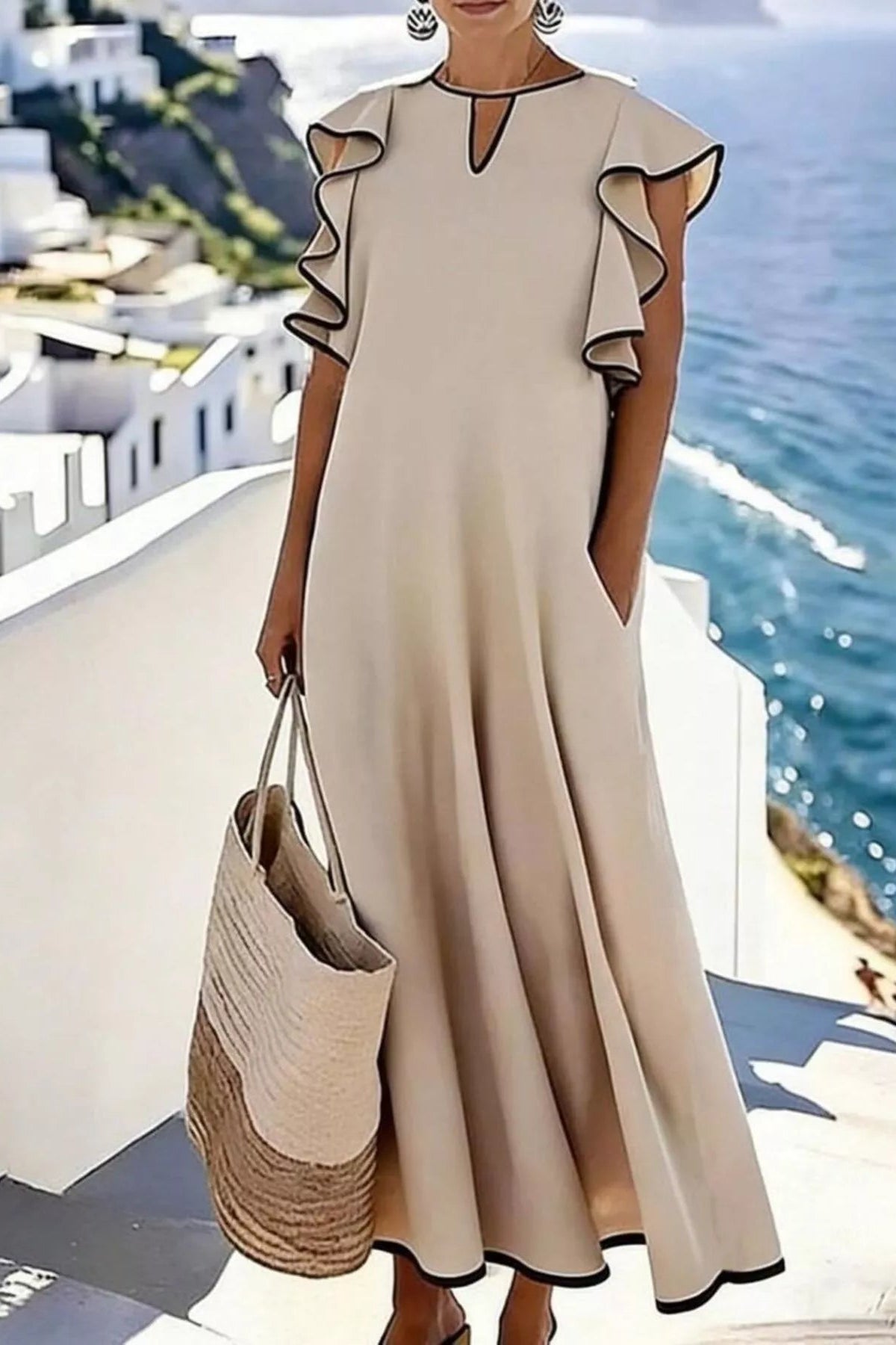 Woman in a beige dress with ruffled sleeves standing on a rooftop with ocean view