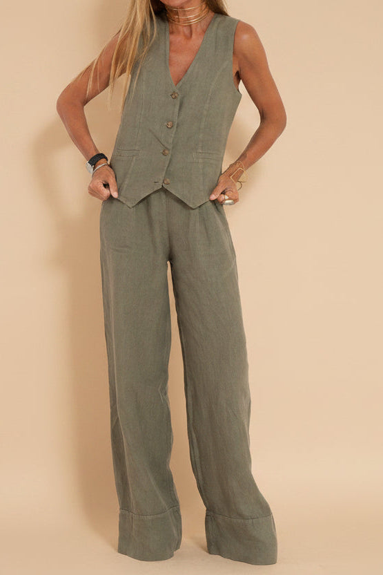 Woman wearing a green vest and pants set against a beige background
