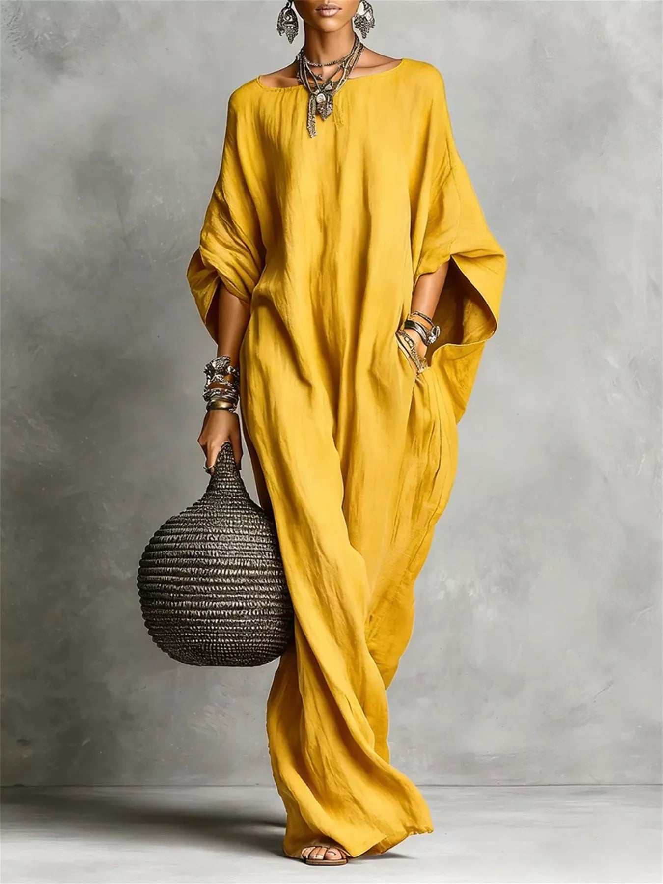 Woman in a yellow dress holding a textured bag against a gray background