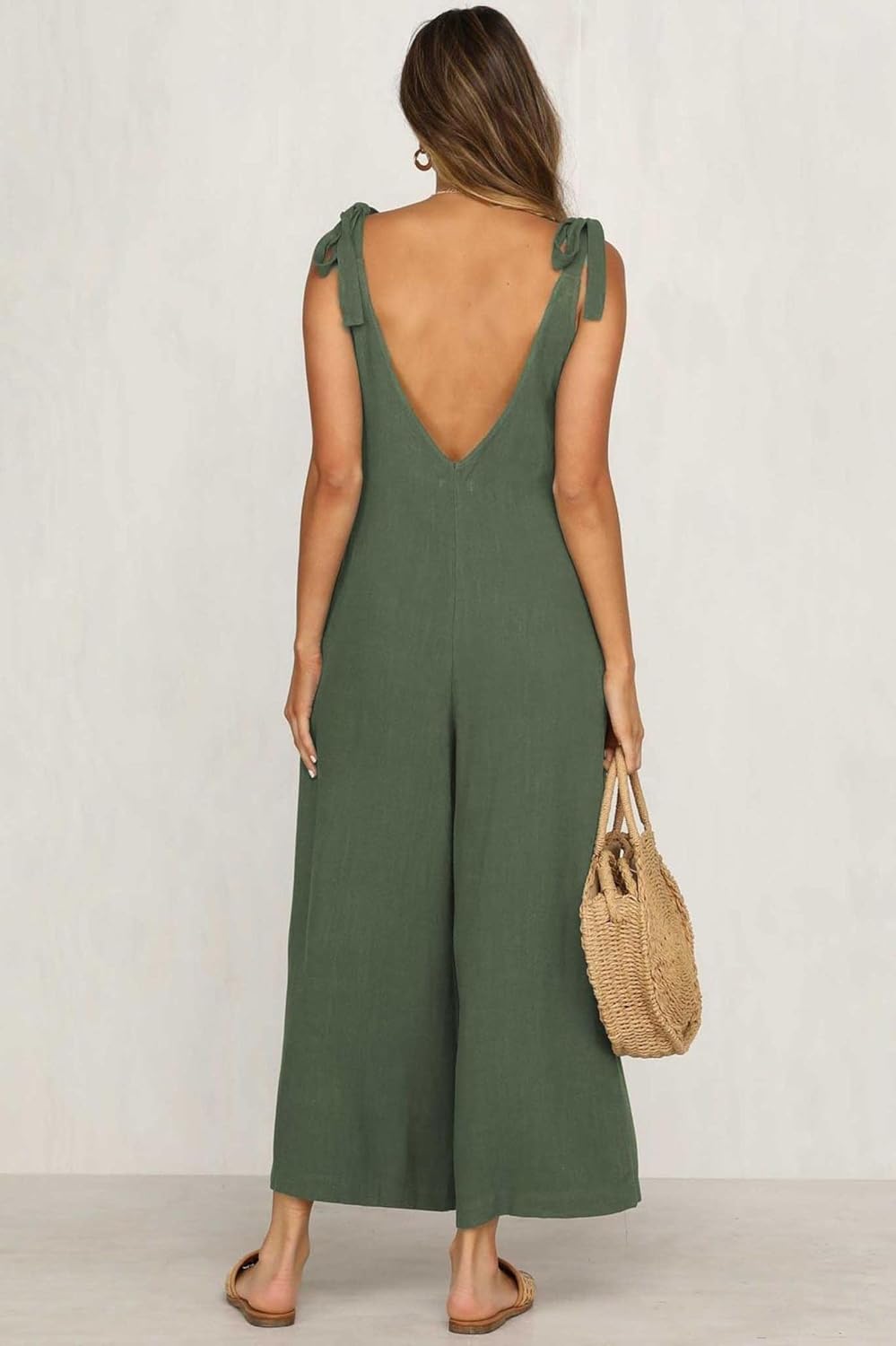 Woman wearing a green jumpsuit with a white background
