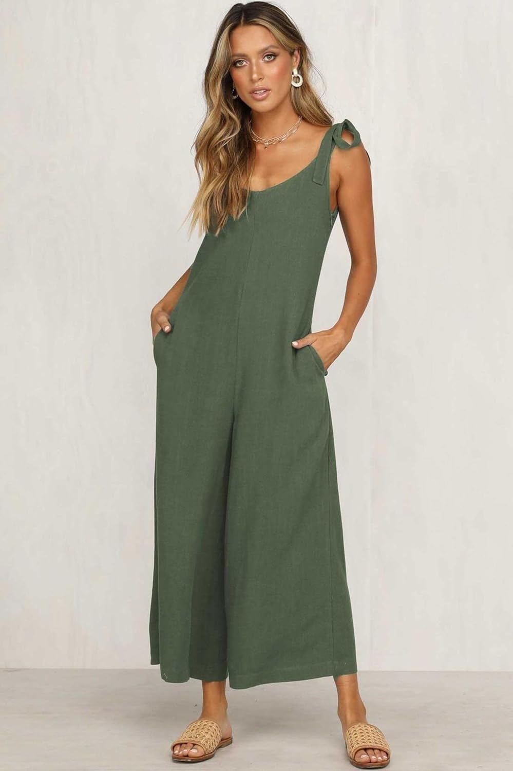 Woman wearing a green jumpsuit against a white background