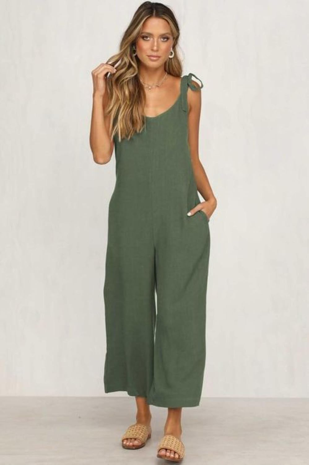Woman wearing a green jumpsuit on a plain background