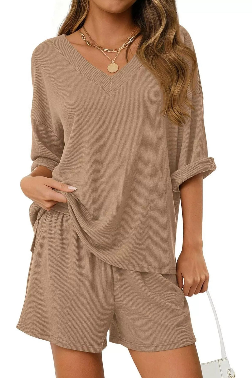 Woman wearing a beige lounge set on a white background