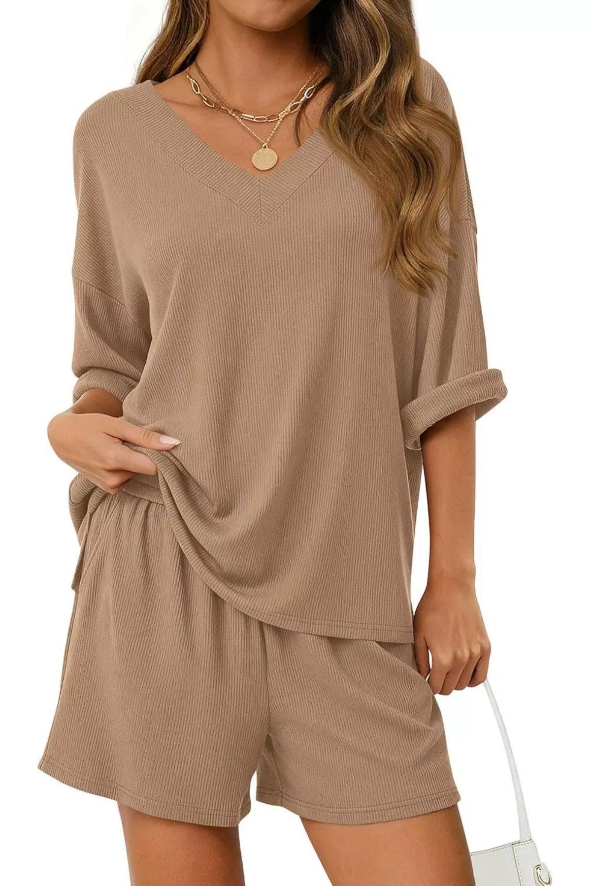 Woman wearing a beige lounge set on a white background