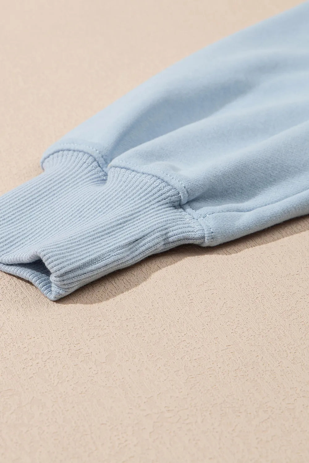 Light blue sweater on a beige surface