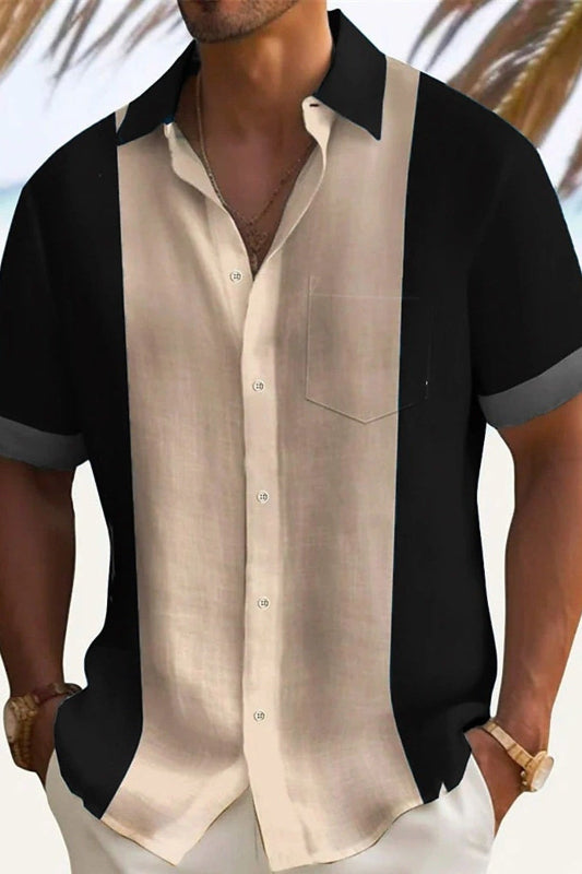 Man wearing a black and beige button-up shirt with a blurred background