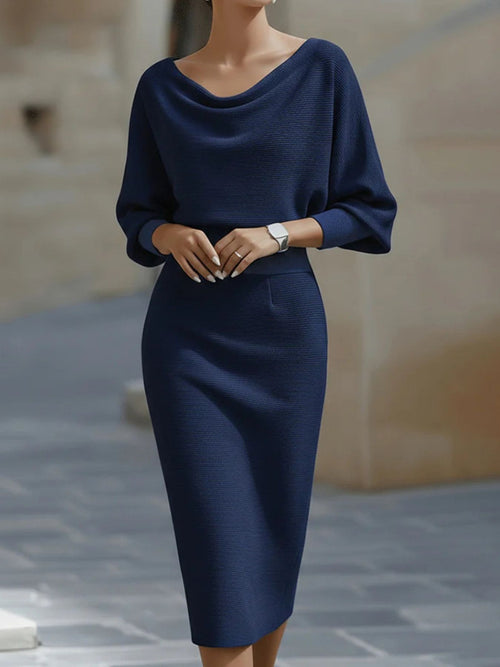Navy blue dress worn by a person on a blurred outdoor background
