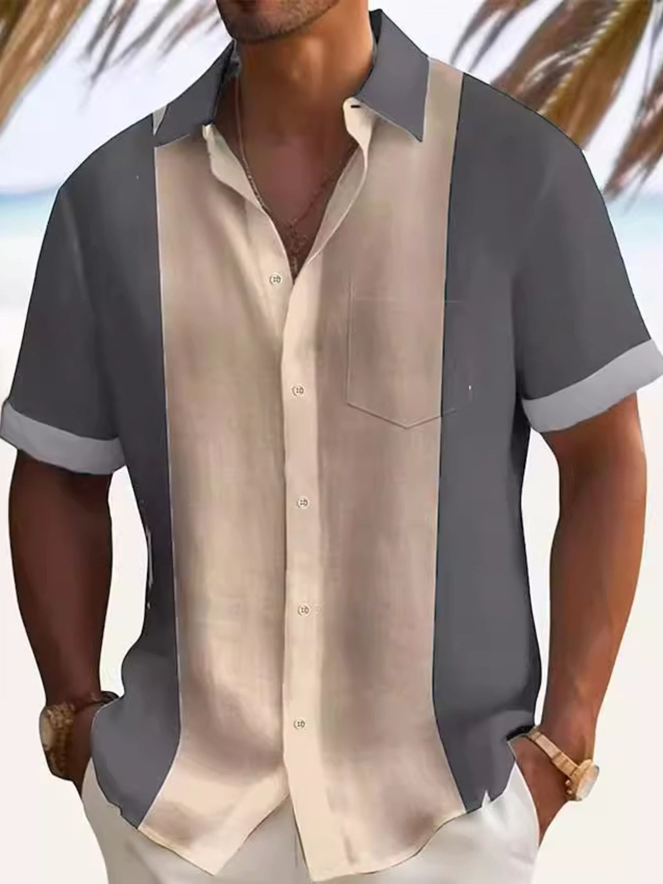 Man wearing a two-tone shirt with gray sleeves and beige body against a blurred beach background