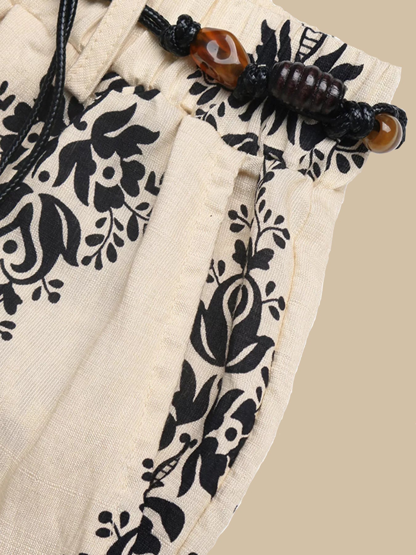 Drawstring with black floral patterns on beige fabric