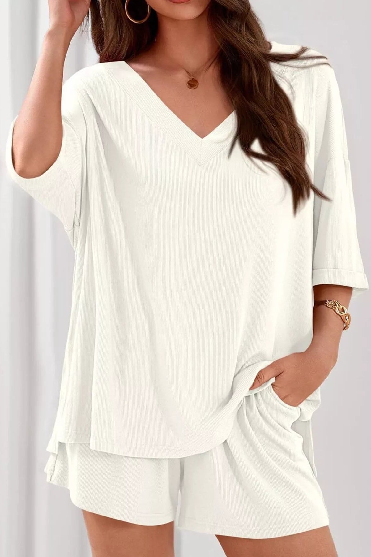 Woman wearing a white outfit with a plain background