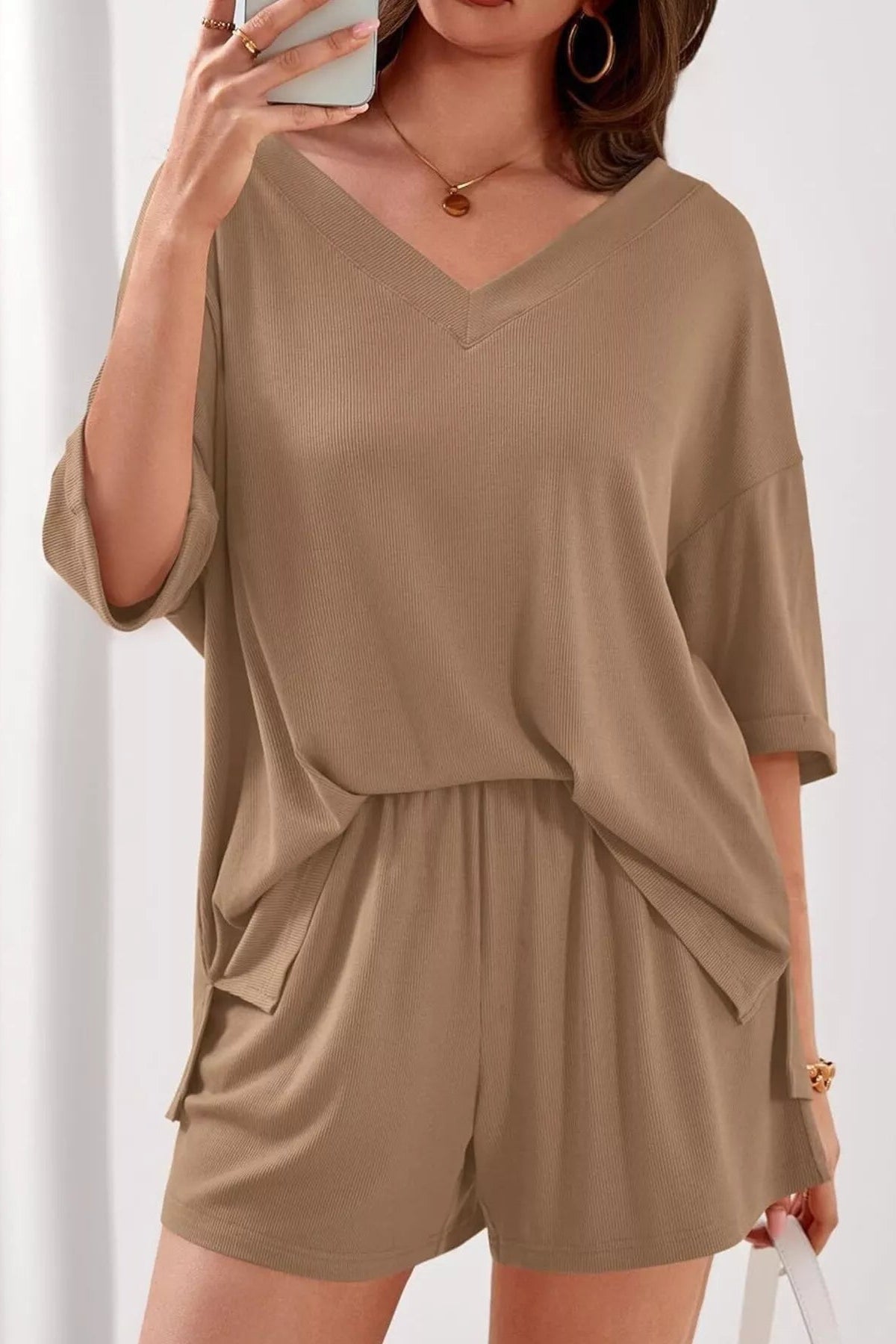 Woman wearing a beige romper against a white background