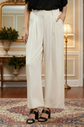 woman wearing ivory-colored wide-leg pants in a living room