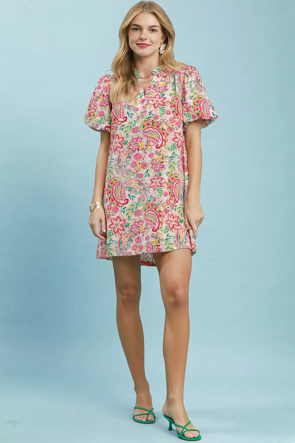 Woman wearing a paisley floral midi dress on a light blue background