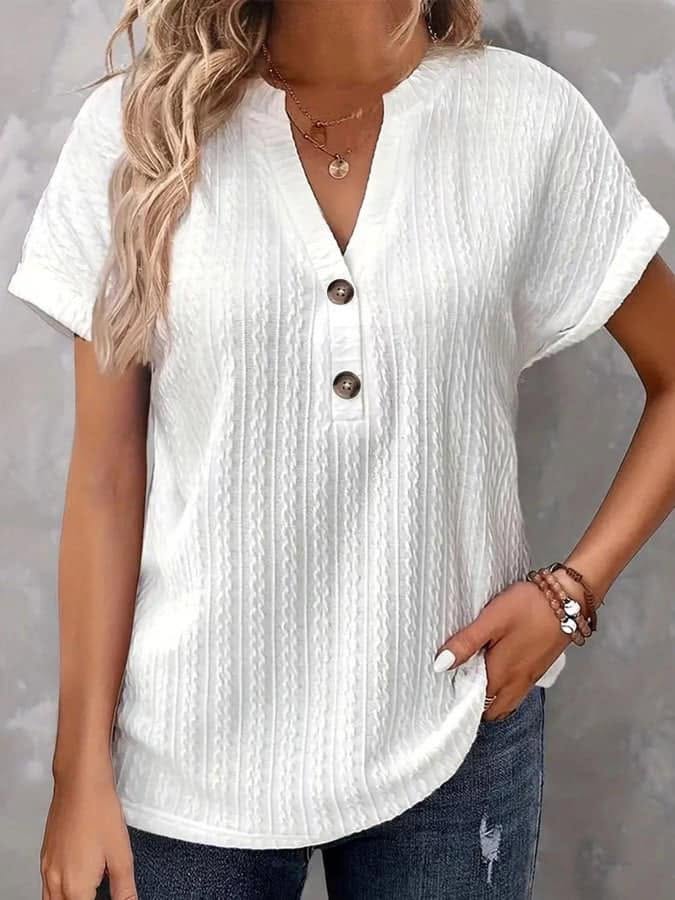 Woman wearing a white textured button-up shirt with a gray background